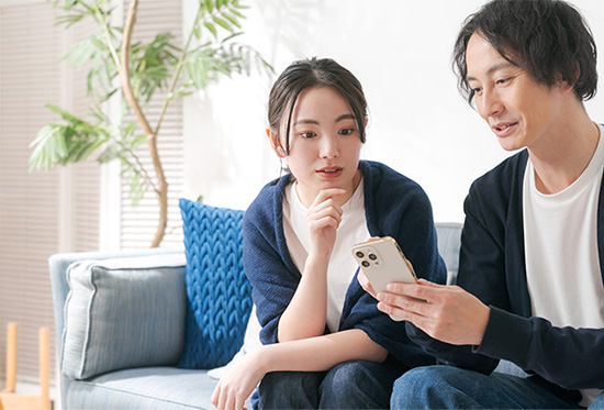 スマートフォンを一緒に見る夫婦