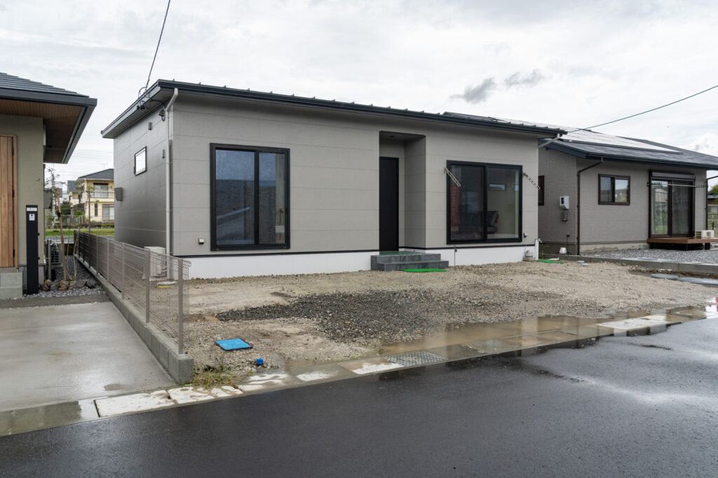 斜めから見たグレーの外壁の平屋